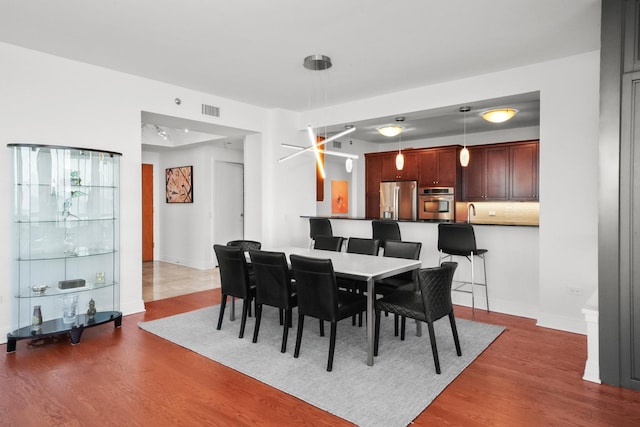 dining space featuring baseboards, visible vents, and dark wood-style flooring