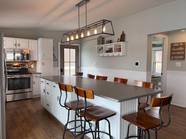 5-124 Sunrise Ct, Lanark, IL 61046 - kitchen featuring a wainscoted wall, appliances with stainless steel finishes, dark countertops, and white cabinets
