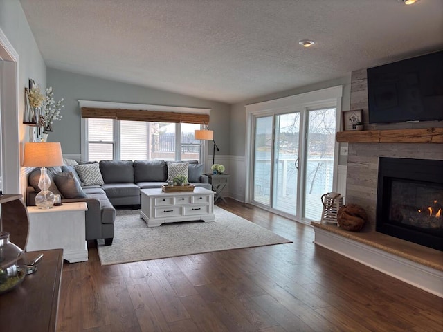 5-124 Sunrise Ct, Lanark, IL 61046 - living room with dark wood-style flooring, a wainscoted wall, a fireplace, and a textured ceiling