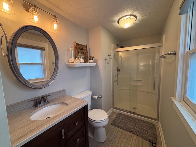 5-124 Sunrise Ct, Lanark, IL 61046 - full bathroom with a textured ceiling, toilet, wood finished floors, vanity, and a stall shower