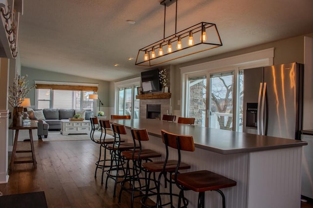 5-124 Sunrise Ct, Lanark, IL 61046 - kitchen featuring appliances with stainless steel finishes, open floor plan, a large fireplace, and dark wood-style flooring