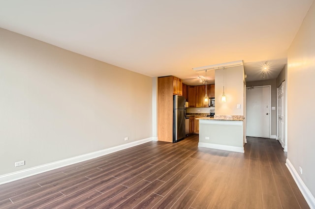 kitchen featuring appliances with stainless steel finishes, dark wood-style flooring, and baseboards