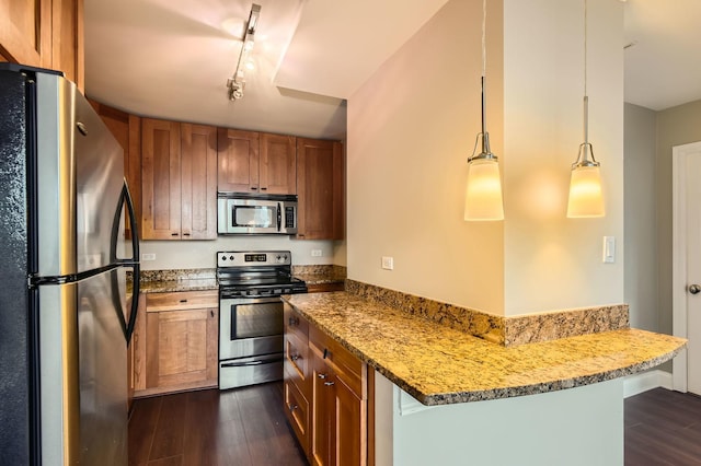 kitchen featuring brown cabinets, dark wood-type flooring, a peninsula, light stone countertops, and stainless steel appliances