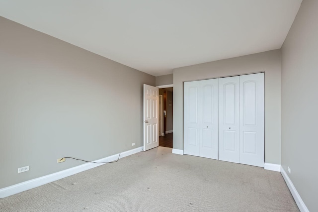 unfurnished bedroom featuring a closet, baseboards, and carpet flooring