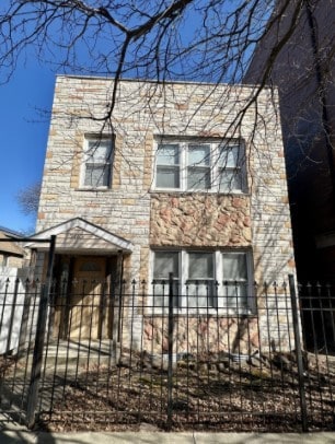 view of front of house featuring a fenced front yard and stone siding