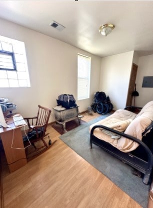 bedroom featuring visible vents and wood finished floors
