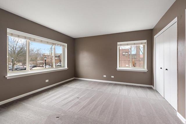 unfurnished bedroom featuring a closet, carpet, and baseboards