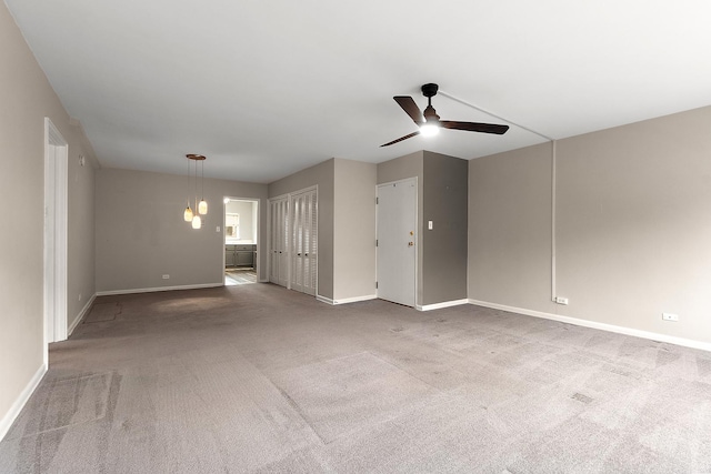 unfurnished living room featuring ceiling fan, carpet flooring, and baseboards