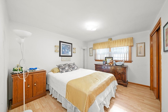 bedroom featuring light wood-style floors and baseboards