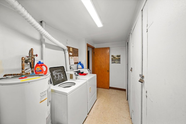 clothes washing area featuring light floors, water heater, laundry area, and washer and dryer