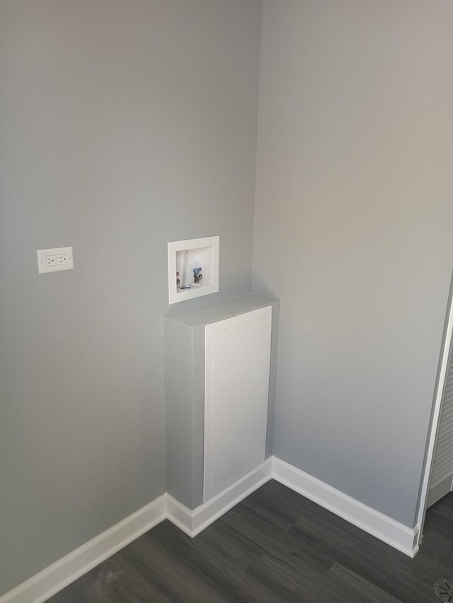 clothes washing area with dark wood-style floors, washer hookup, laundry area, and baseboards