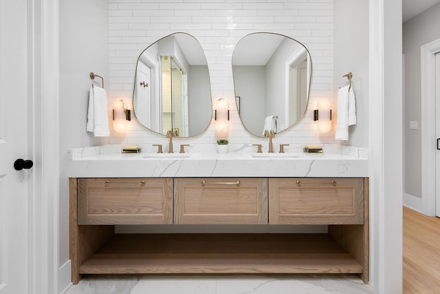 full bathroom featuring double vanity, tasteful backsplash, and a sink