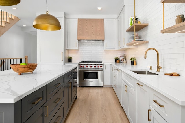 kitchen with open shelves, white cabinetry, luxury range, and a sink