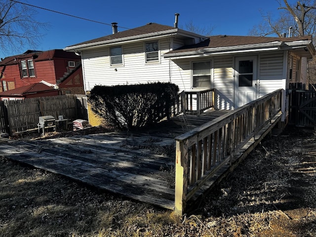 rear view of property featuring fence and a deck