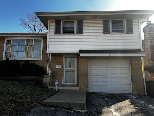 tri-level home featuring brick siding and an attached garage