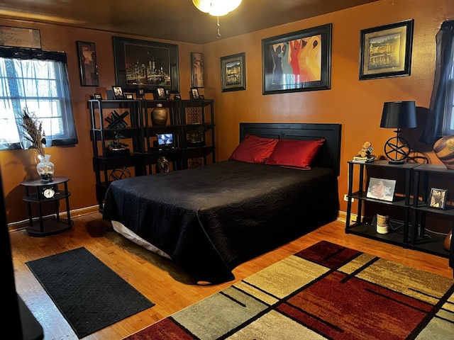 bedroom featuring baseboards and wood finished floors