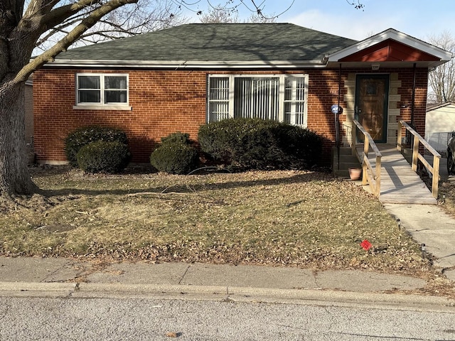 single story home with brick siding and a shingled roof