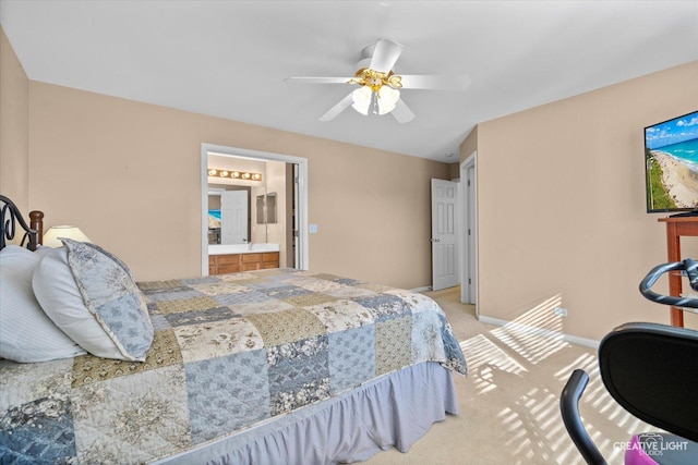 bedroom featuring light carpet, ceiling fan, baseboards, and ensuite bathroom