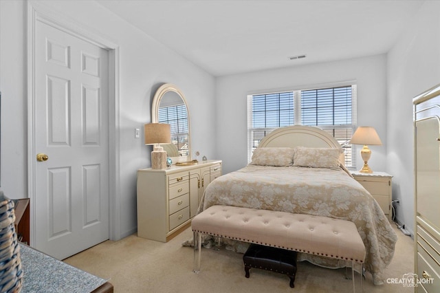 bedroom with light colored carpet, visible vents, and multiple windows