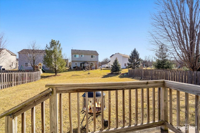 wooden terrace featuring a lawn and a fenced backyard