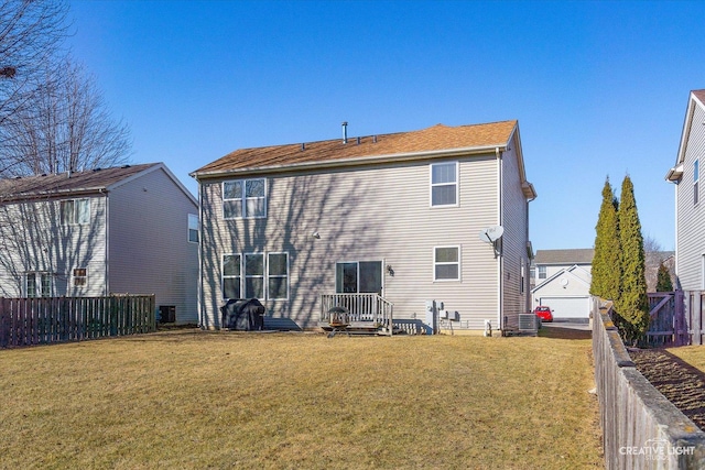 rear view of property featuring a yard and fence