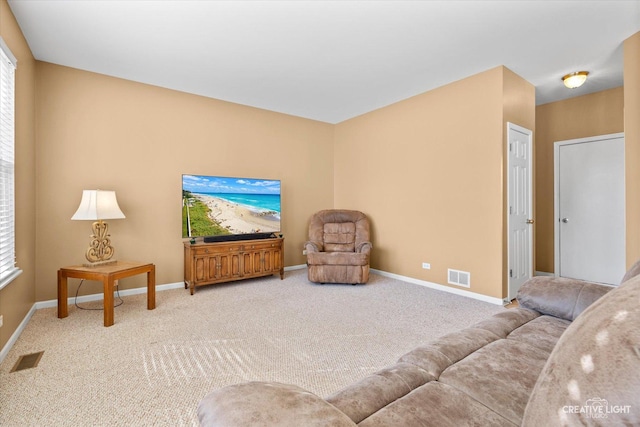 living area with carpet, visible vents, and baseboards