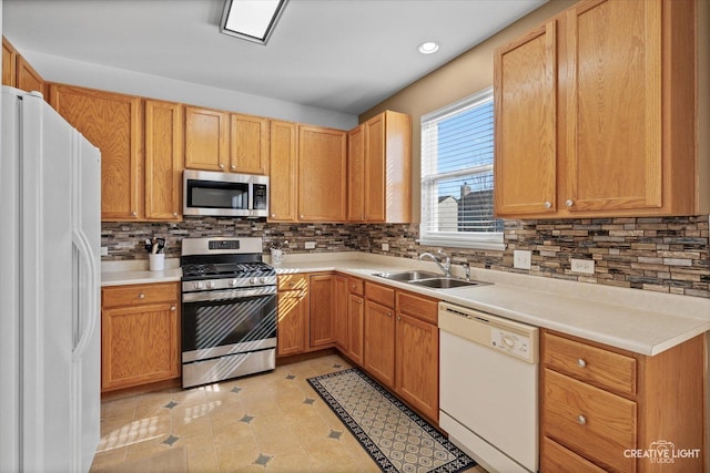 kitchen featuring stainless steel appliances, recessed lighting, tasteful backsplash, light countertops, and a sink