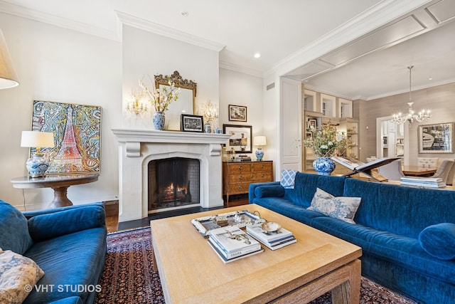 living room featuring a chandelier, a lit fireplace, ornamental molding, recessed lighting, and wood finished floors