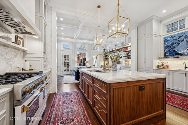 kitchen with beamed ceiling, range hood, high end stainless steel range oven, coffered ceiling, and a sink