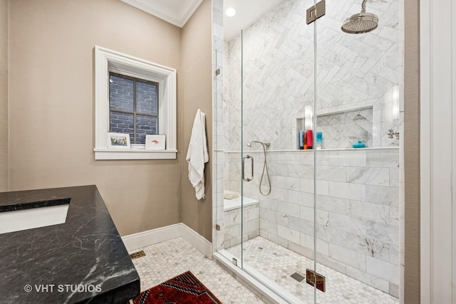 bathroom with a sink, a shower stall, baseboards, and ornamental molding