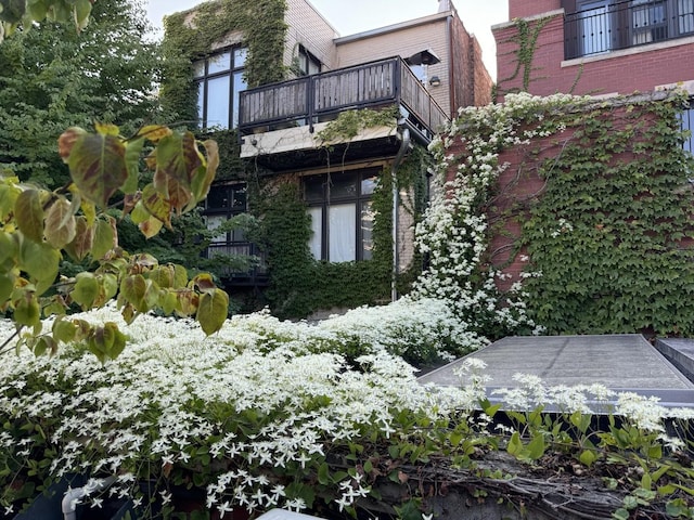 view of side of property featuring a balcony and brick siding