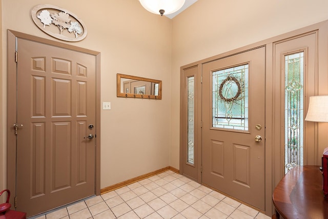 foyer entrance with light tile patterned floors and baseboards