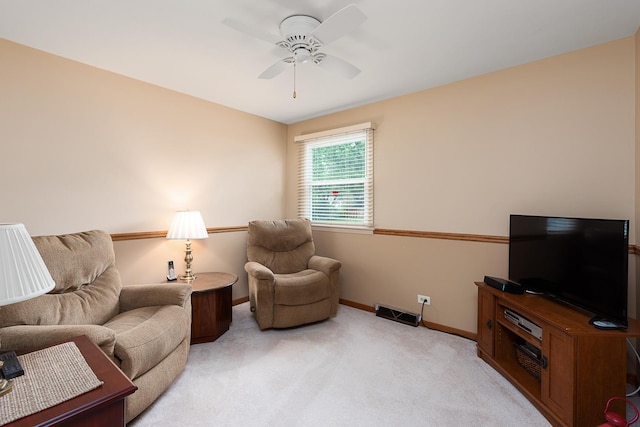 living area featuring ceiling fan, visible vents, baseboards, and light colored carpet