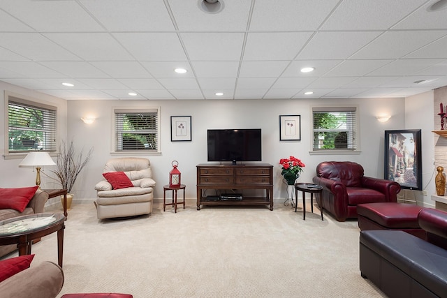 living room featuring recessed lighting, light colored carpet, a drop ceiling, and baseboards