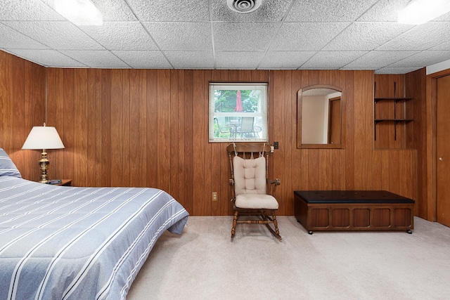 carpeted bedroom with visible vents and wooden walls