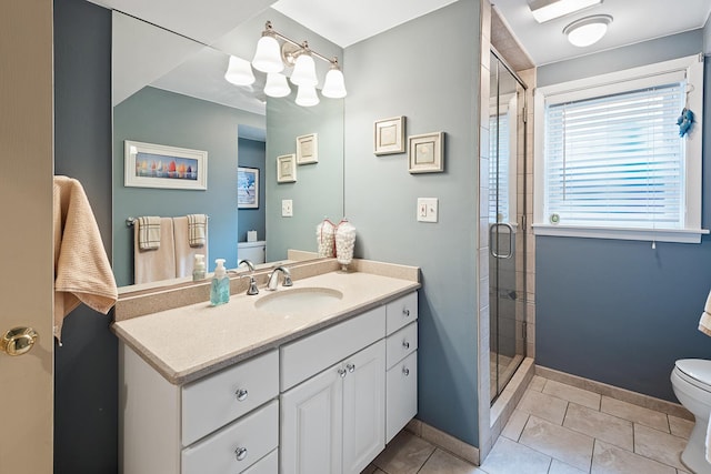 full bathroom featuring tile patterned flooring, toilet, vanity, baseboards, and a shower stall