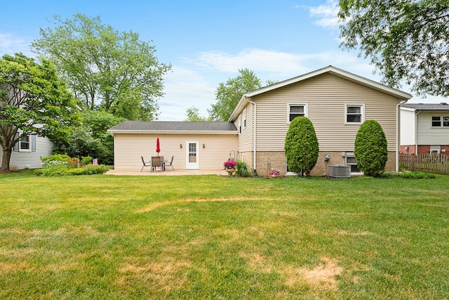 back of property featuring central AC, brick siding, fence, a lawn, and a patio area