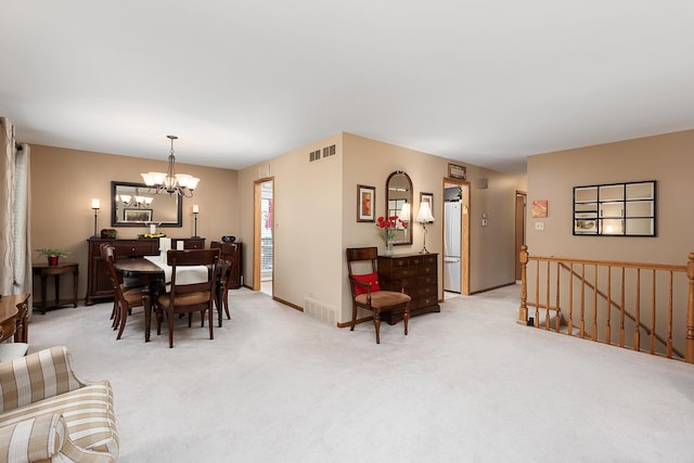 dining room featuring an inviting chandelier, baseboards, visible vents, and light colored carpet