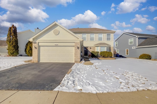 view of front of property featuring driveway, brick siding, and an attached garage