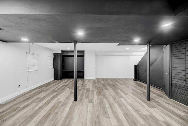 finished below grade area featuring recessed lighting, light wood-style flooring, and baseboards