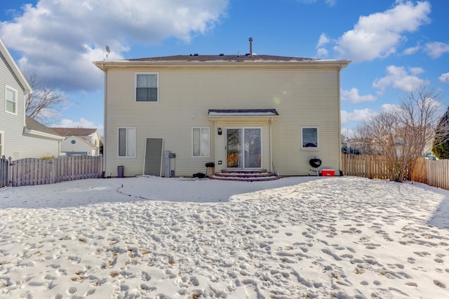 snow covered house with fence