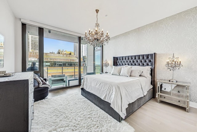 bedroom with access to outside, expansive windows, wood finished floors, wallpapered walls, and baseboards