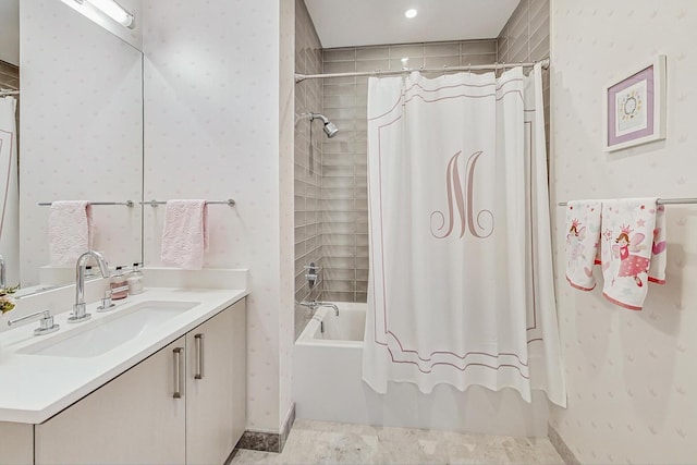 bathroom with wallpapered walls, vanity, and shower / bath combo