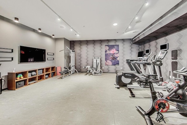 exercise room with track lighting and wallpapered walls