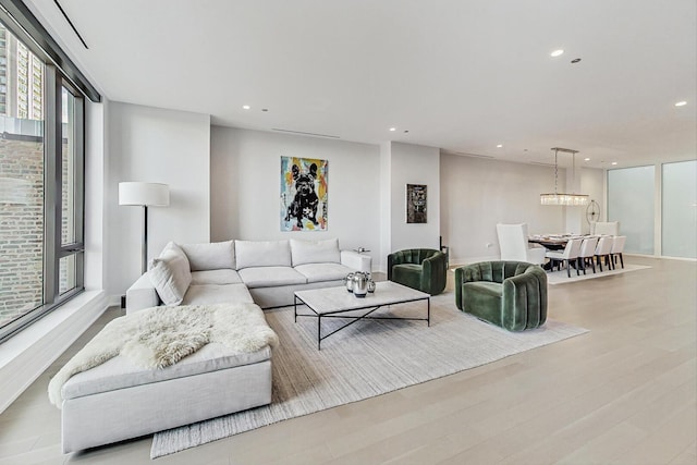 living room with floor to ceiling windows, recessed lighting, and wood finished floors