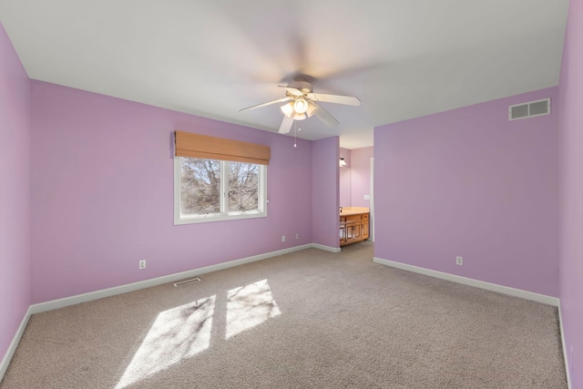 spare room featuring carpet, baseboards, and visible vents