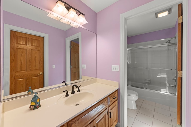 full bath with tile patterned flooring, shower / bath combination with glass door, vanity, and toilet