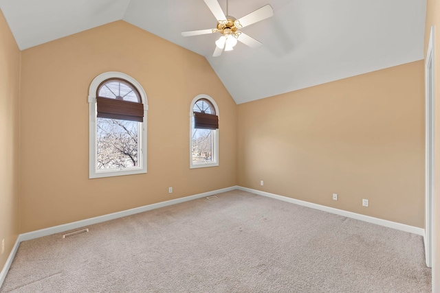 unfurnished room with visible vents, carpet flooring, vaulted ceiling, ceiling fan, and baseboards