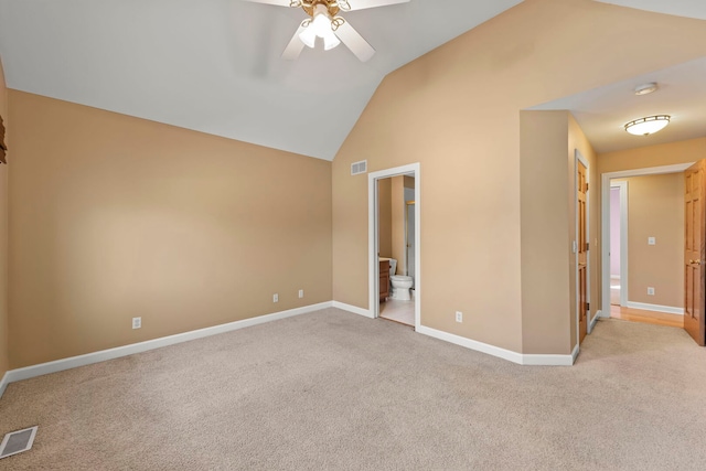 unfurnished room with visible vents, vaulted ceiling, and light carpet