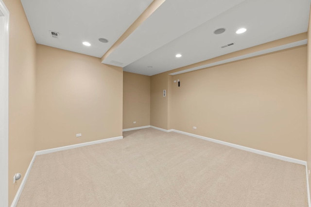 spare room with visible vents, light carpet, and baseboards